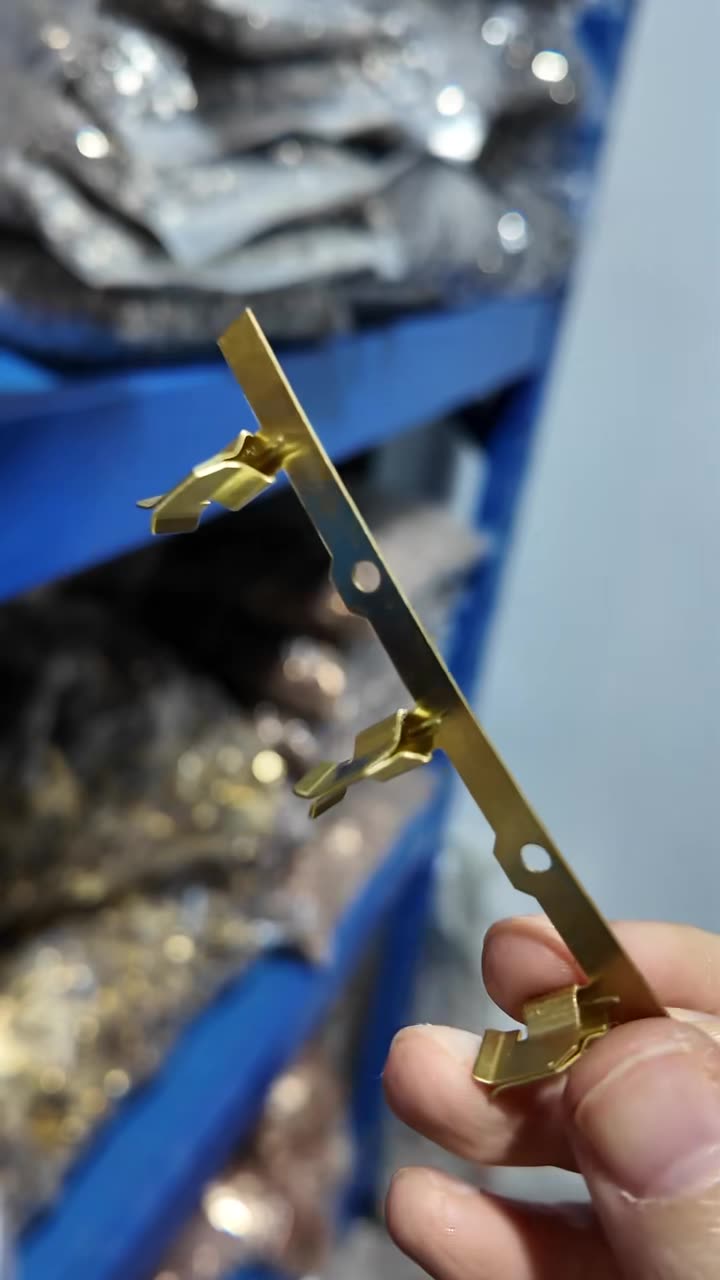 Brass connection plate part held next to storage bins